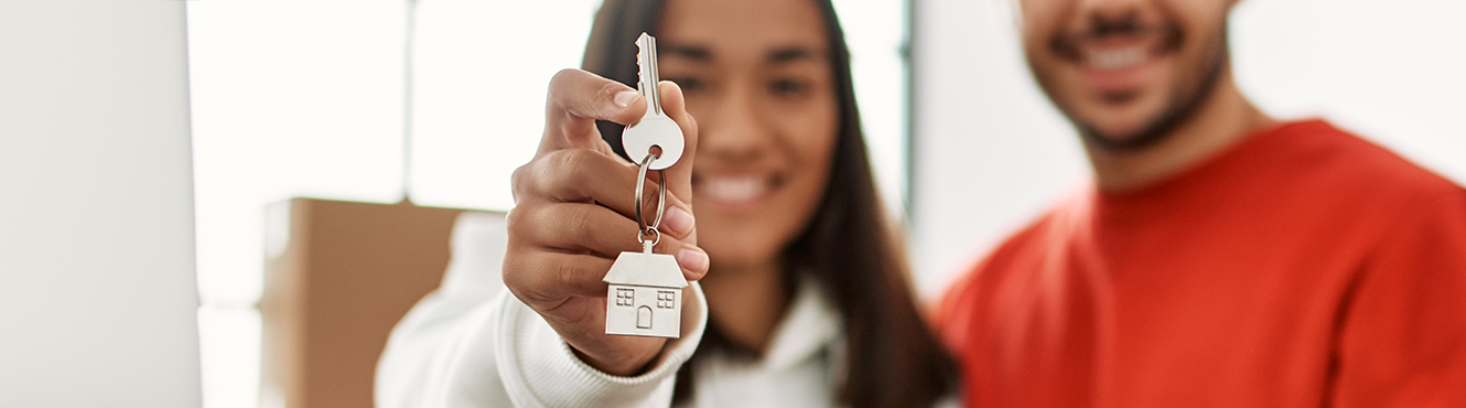 Couple holding keys to their new home.