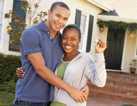 Couple in front of newly purchased home.