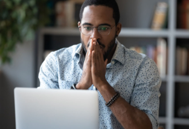 Man realizing he is a victim of fraud when checking his finances online.