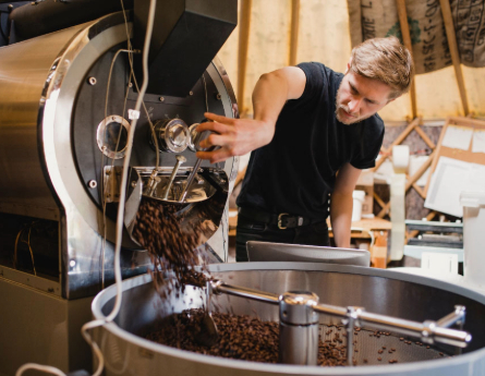 Person using their new coffee manufacturing equipment.