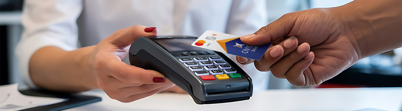 Woman handing over debit card tom make a purchase with a merchant