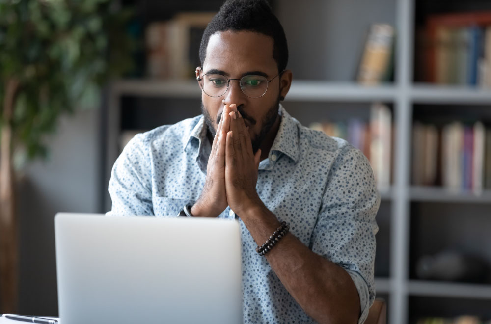 Man realizing he is a victim of fraud when checking his finances online.